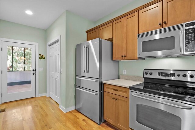 kitchen featuring stainless steel appliances and light hardwood / wood-style flooring