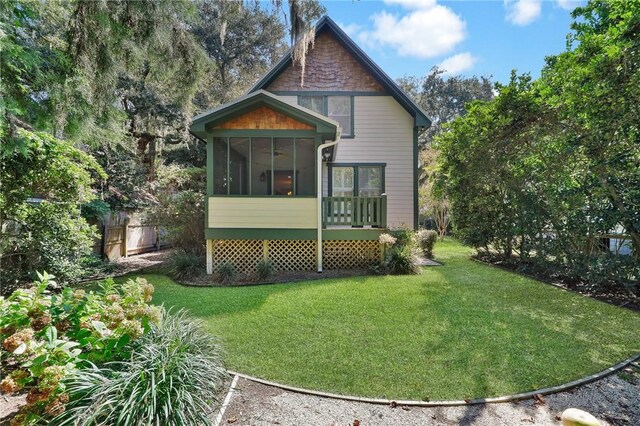 view of home's exterior with a lawn and a sunroom