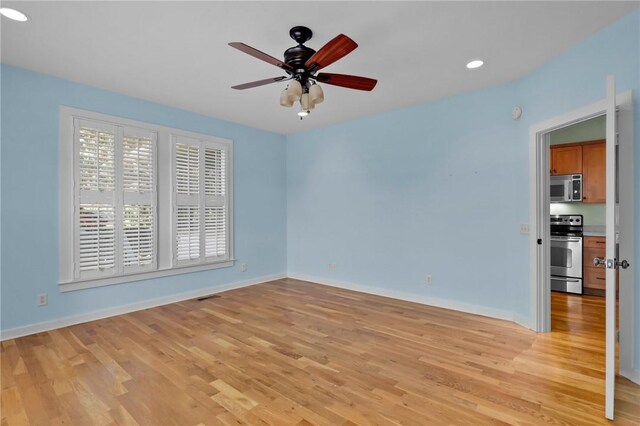 spare room featuring ceiling fan and light hardwood / wood-style floors