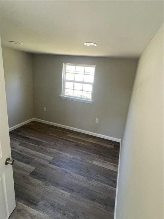 unfurnished room with dark wood finished floors and baseboards