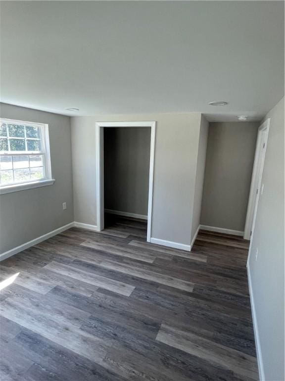 empty room with baseboards and dark wood-style flooring