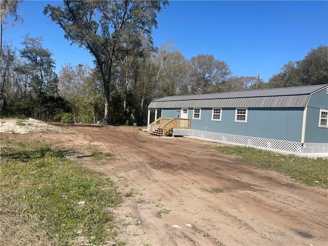 manufactured / mobile home featuring a wooden deck, a gambrel roof, and metal roof