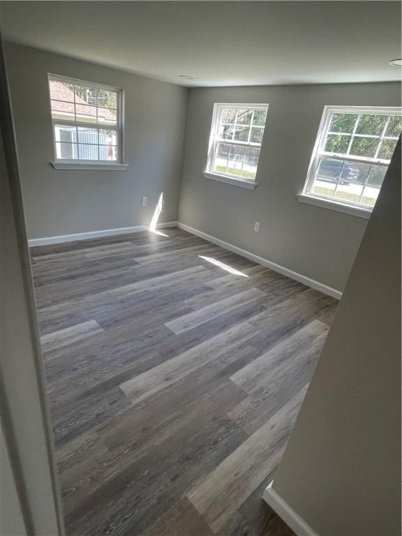 empty room featuring dark wood-style floors and baseboards