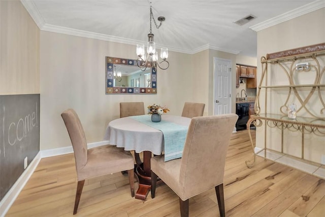 dining room with crown molding, a chandelier, sink, and light wood-type flooring