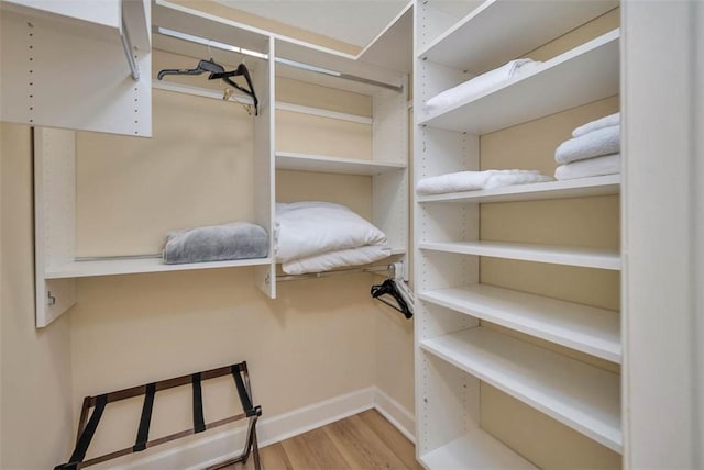 walk in closet with light hardwood / wood-style flooring