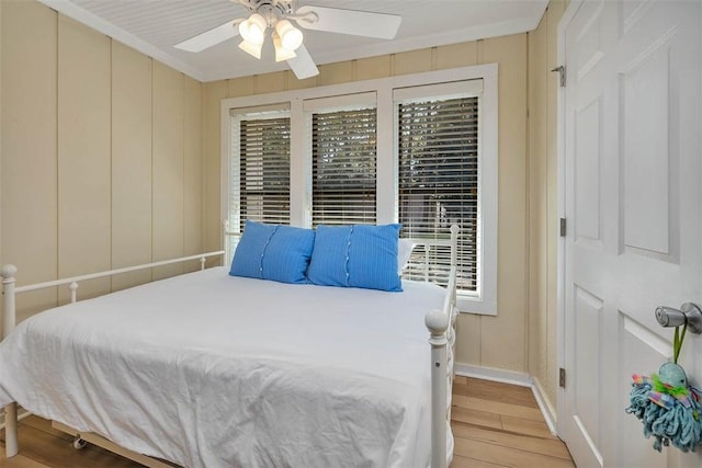 bedroom featuring crown molding, ceiling fan, and light wood-type flooring