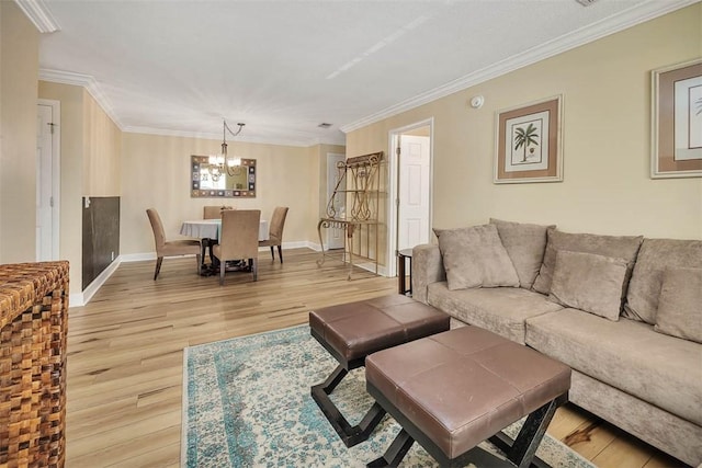 living room featuring crown molding, a chandelier, and light wood-type flooring