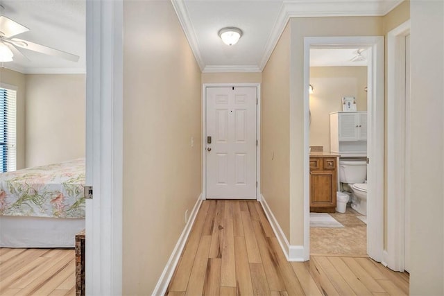 corridor with ornamental molding and light wood-type flooring