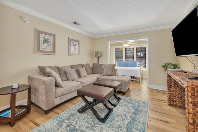 living room featuring ornamental molding, light hardwood / wood-style floors, and a textured ceiling