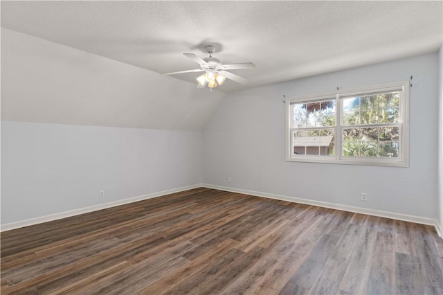 additional living space with ceiling fan, dark wood-type flooring, and vaulted ceiling