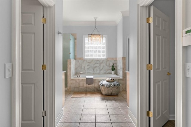 bathroom with tiled bath, an inviting chandelier, ornamental molding, and tile patterned flooring