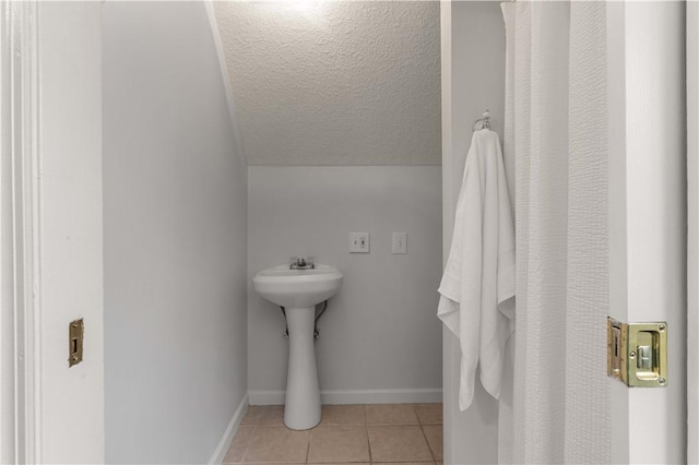 bathroom with lofted ceiling and tile patterned floors