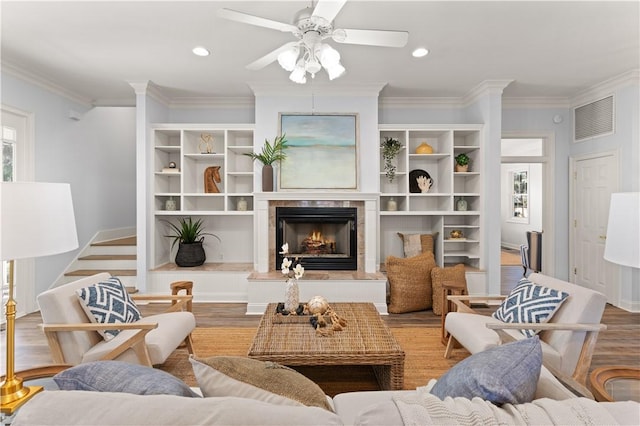 living room with ceiling fan, crown molding, and light hardwood / wood-style floors