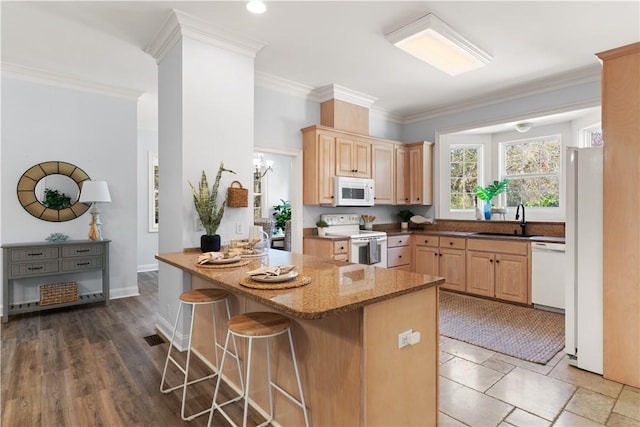 kitchen featuring sink, kitchen peninsula, a breakfast bar, and white appliances