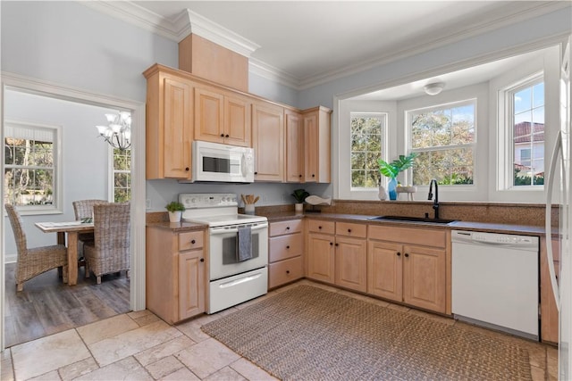 kitchen with light brown cabinetry, an inviting chandelier, sink, and white appliances