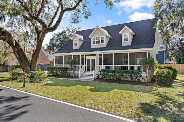 cape cod house featuring a front yard and a sunroom