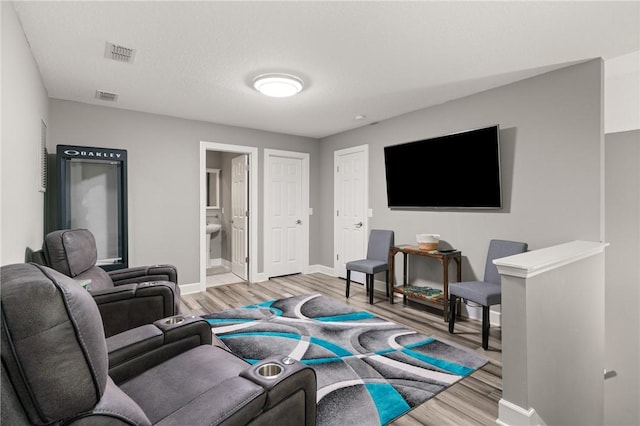 living room featuring baseboards, visible vents, and wood finished floors
