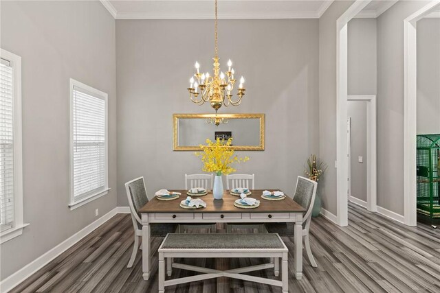 dining area featuring baseboards, a chandelier, ornamental molding, and wood finished floors