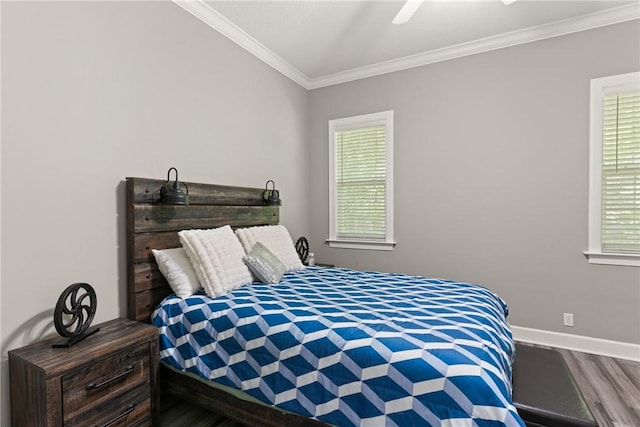 bedroom with baseboards, ornamental molding, wood finished floors, and multiple windows