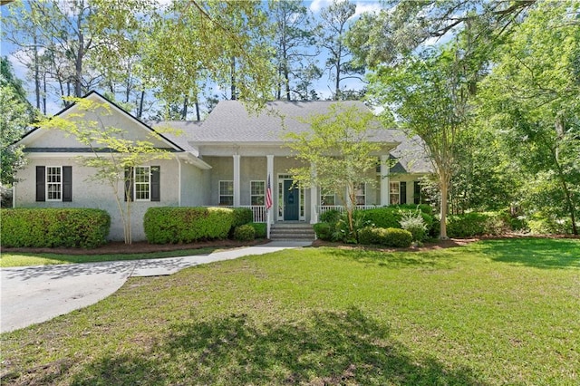 view of front of house featuring stucco siding, covered porch, and a front yard