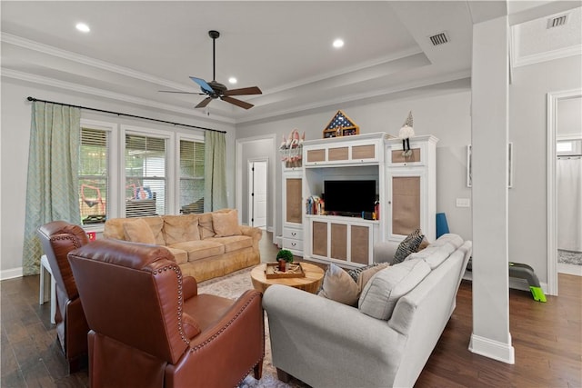 living room featuring ceiling fan, crown molding, dark wood-type flooring, and a tray ceiling