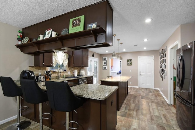 109 Mackay Cir, Brunswick, GA 31525 - kitchen featuring light wood-type flooring, refrigerator, dark brown cabinetry, pendant lighting, and a kitchen island