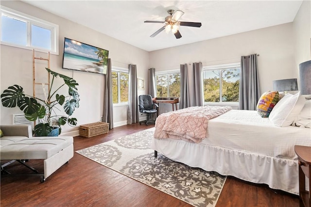 bedroom with a ceiling fan, dark wood finished floors, and baseboards