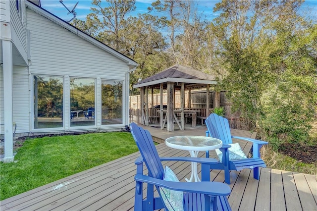 deck featuring fence, a gazebo, and a lawn