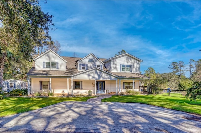 view of front of house featuring a front lawn, a porch, and fence