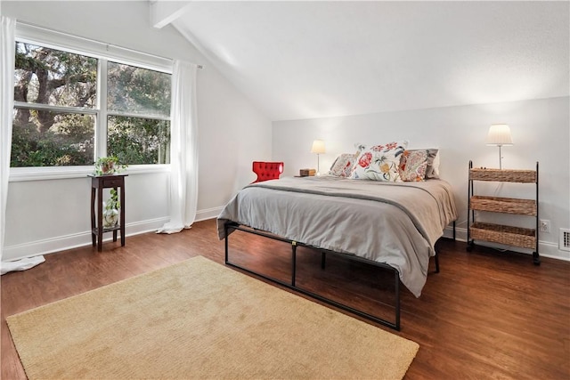 bedroom featuring lofted ceiling with beams, dark wood-style flooring, and baseboards