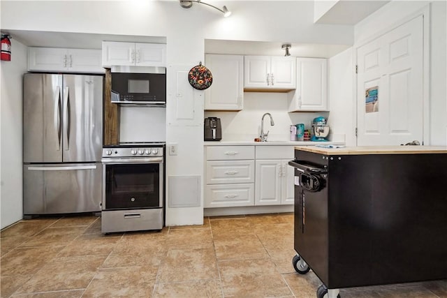 kitchen with white cabinets, appliances with stainless steel finishes, light countertops, and a sink