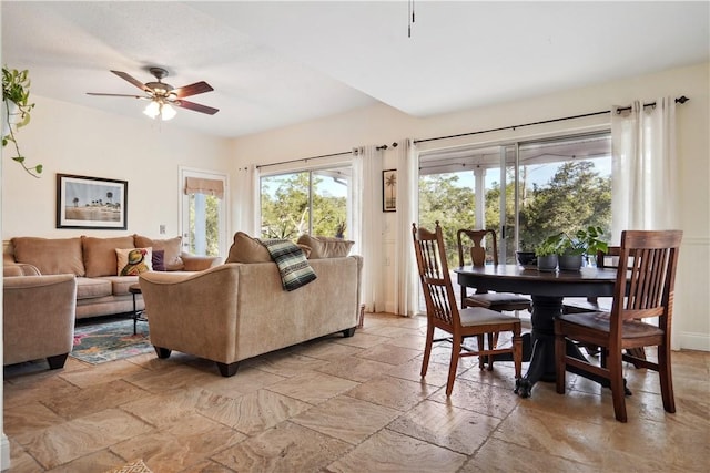 living room featuring ceiling fan and stone tile flooring