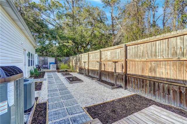 view of patio / terrace with a fenced backyard, a vegetable garden, and central AC unit