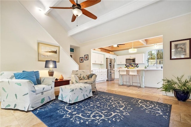 living area featuring lofted ceiling with beams and ceiling fan