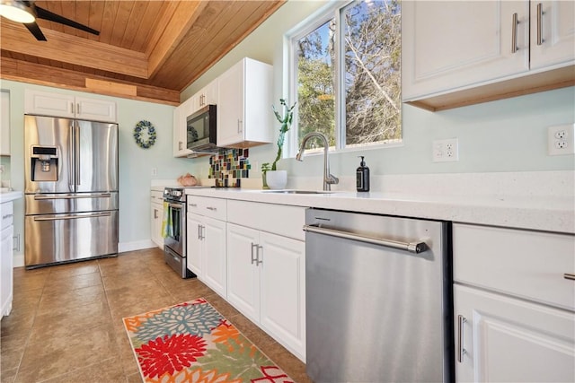 kitchen with stainless steel appliances, wooden ceiling, light countertops, and white cabinets