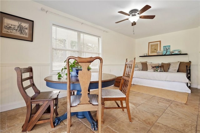 dining room featuring a ceiling fan and wainscoting