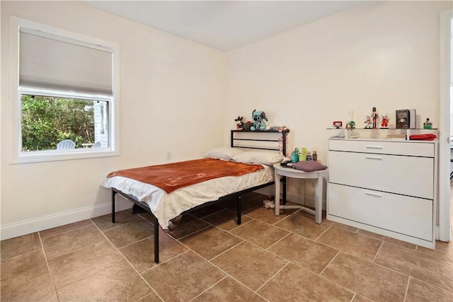 bedroom with baseboards and light tile patterned floors