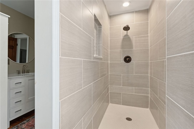 bathroom with vanity and tiled shower