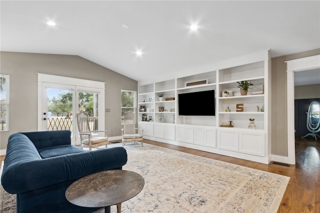 living room featuring lofted ceiling, hardwood / wood-style floors, and built in features