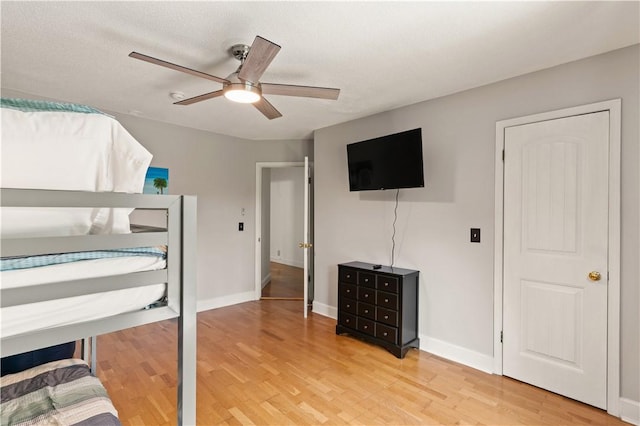 bedroom featuring a ceiling fan, light wood-type flooring, and baseboards