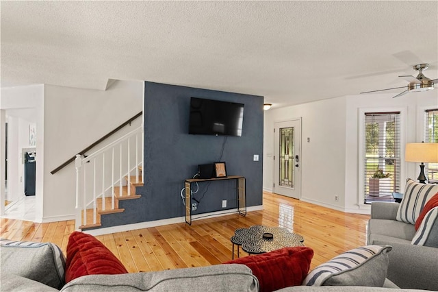 living room with hardwood / wood-style floors, stairs, and a textured ceiling