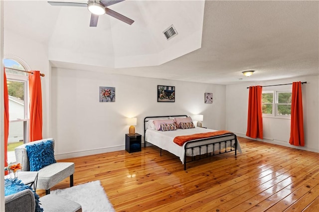 bedroom with visible vents, baseboards, a ceiling fan, and light wood finished floors