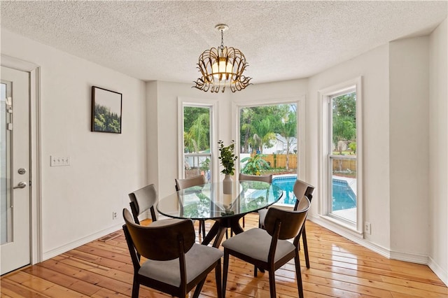 dining space with a chandelier, light wood finished floors, and a wealth of natural light