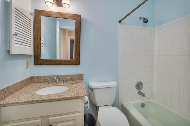 full bathroom featuring tiled shower / bath combo, toilet, and vanity