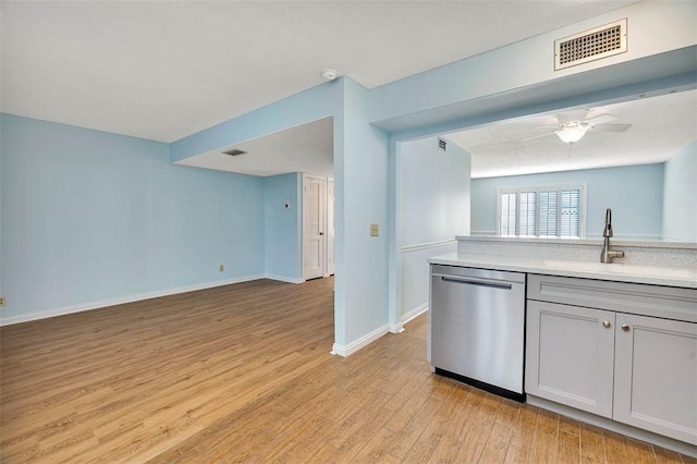 kitchen featuring ceiling fan, sink, stainless steel dishwasher, and light hardwood / wood-style floors