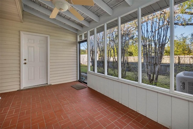 unfurnished sunroom featuring a wealth of natural light, lofted ceiling with beams, and ceiling fan