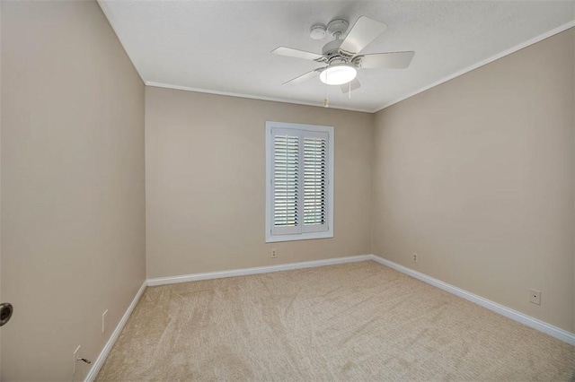 carpeted empty room with ceiling fan and crown molding