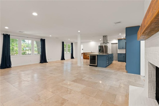 kitchen with open floor plan, wine cooler, blue cabinets, and stainless steel fridge with ice dispenser