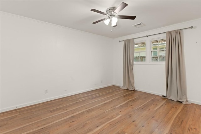 unfurnished room with crown molding, a ceiling fan, visible vents, and light wood-style floors