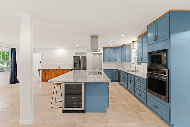 kitchen with blue cabinets, island exhaust hood, a sink, beverage cooler, and stainless steel appliances
